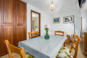 stół w jadalni z wazonem kwiatów na nim w obiekcie Apartment Lanterna Veneziana w Rovinj