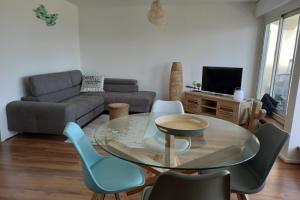 - un salon avec une table et des chaises en verre dans l'établissement Superb Apartment Near The Sea, à Arcachon