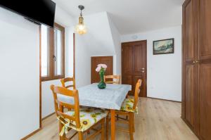 stół w jadalni z wazonem kwiatów na nim w obiekcie Apartment Lanterna Veneziana w Rovinj +8 zdjęć