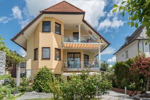 a yellow house with a tiled roof at Ferienwohnung Wolf Überlingen in Überlingen