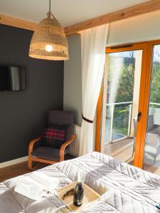 a bedroom with a bed and a chair and a window at Apartament MONTANA in Karpacz