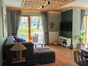 a living room with a couch and a tv at Apartament MONTANA in Karpacz