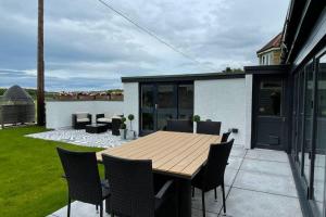 a wooden table and chairs on a patio at Castle View House in Dalkeith