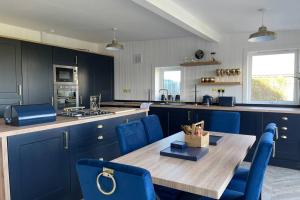 a kitchen with a wooden table and blue chairs at Castle View House in Dalkeith
