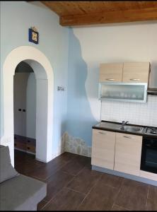 a small kitchen with a sink and an archway at dastemi in Parghelia