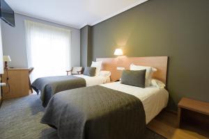 En eller flere senger på et rom på Hotel Porto do Barqueiro