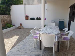 a table and chairs sitting on a patio at Apartments Dora in Pag