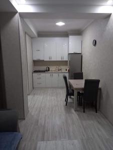 a kitchen and dining room with a table and chairs at 1home in Rustavi