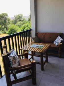 eine Bank und einen Tisch auf einem Balkon mit einem Sofa in der Unterkunft 1home in Rustawi