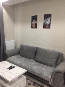 a living room with a couch and three pictures on the wall at 1home in Rustavi
