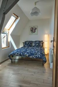 Schlafzimmer mit einem Bett mit blauer Decke in der Unterkunft AU COCON CASSELOIS in Cassel