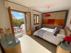 1 dormitorio con 1 cama y balcón en Villa Bianca, en Villa Celiera