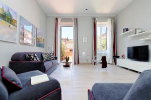 ein Wohnzimmer mit 2 Sofas und einem TV in der Unterkunft Piazzetta Margutta - My Extra Home in Rom