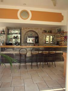 a bar with four stools in a kitchen at camping mas du sartre in Auriolles