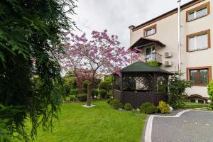 un giardino con gazebo di fronte a un edificio di Astra Apartments a Oświęcim