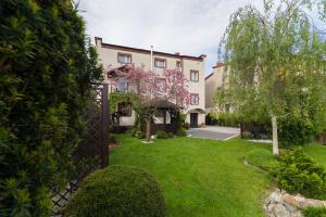 a house with a green yard with a fence at Astra Apartments in Oświęcim