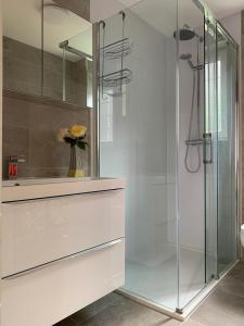 a glass shower in a bathroom with a vase of flowers at Causewayside in Edinburgh
