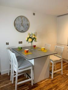 mesa de comedor con sillas y reloj en la pared en Causewayside en Edimburgo