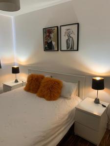 a bedroom with a bed with white sheets and two lamps at Causewayside in Edinburgh