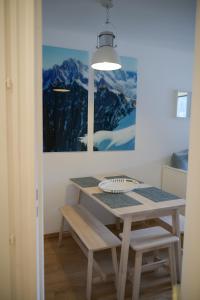 uma sala de jantar com uma mesa e um quadro em Appartement Cosy - Aiguille du Midi em Chamonix-Mont-Blanc