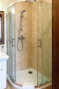 a shower with a glass enclosure in a bathroom at Apartamenty Furta Dominikańska in Sandomierz