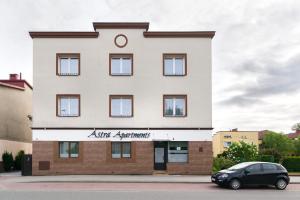 budynek z samochodem zaparkowanym przed nim w obiekcie Astra Apartments w Oświęcimiu