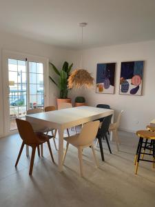 a dining room with a white table and chairs at Tres Terrazas Ocean view apartment in Adeje