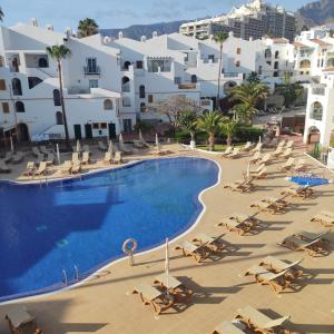 an overhead view of a swimming pool with chairs and buildings at Tres Terrazas Ocean view apartment in Adeje