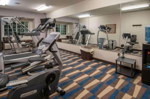 un gimnasio con máquinas de correr y espejo en Microtel Inn & Suites by Wyndham Pearl River/Slidell en Pearl River