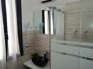 a bathroom with a glass shower with a black sink at Newhouse CRISPI 78 in Bari