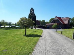 a tree in the grass next to a house at Ferienwohnungen Pöttker in Bad Zwischenahn