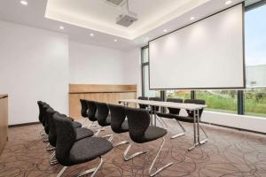 una sala de conferencias con sillas negras y una pizarra en Super 8 by Wyndham Munich City North en Múnich