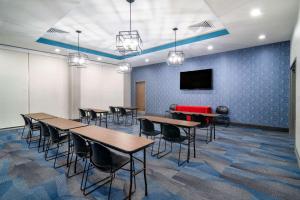 a conference room with tables and chairs and a tv at La Quinta Inn & Suites by Wyndham Louisville NE - Old Henry Rd in Louisville +50 photos