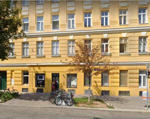 a yellow building with bicycles parked in front of it at LieblingsPlatz in Vienna