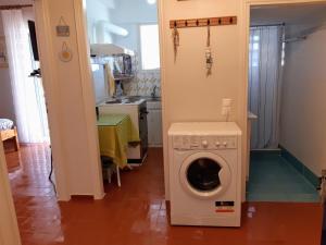 a kitchen with a washing machine in a room at Nea Styra seafront apartment with stunning view in Nea Stira