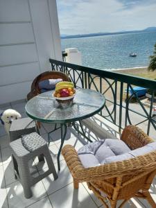 una mesa y sillas con un bol de fruta en el balcón en MARIA'S DREAM HOUSE en Eretria