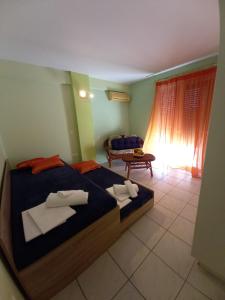 sypialnia z 2 łóżkami, kanapą i oknem w obiekcie MARIA'S DREAM HOUSE w Erétrii