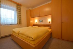 Un dormitorio con una cama grande y una ventana en Landhaus Mitteregger, en Kaprun