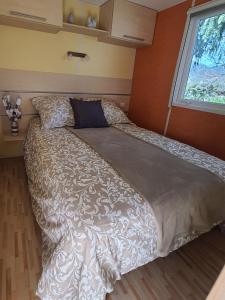 duże łóżko w pokoju z oknem w obiekcie Mobil-home Beau Rivage w mieście Gunsbach