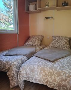 dwa łóżka siedzące obok siebie w pokoju w obiekcie Mobil-home Beau Rivage w mieście Gunsbach