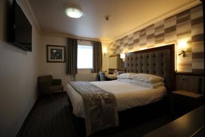 una camera d'albergo con un grande letto e una scrivania di Best Western Plus Pastures Hotel a Doncaster