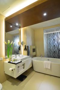 a bathroom with a tub and a sink and a mirror at Lex Hotel Cebu in Cebu City