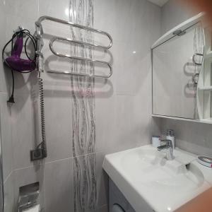 uma casa de banho com um chuveiro, um lavatório e um espelho. em ashlife_home em Liepāja