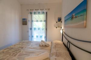 una camera da letto con un letto e due asciugamani di CASA ZEN A GEREMEAS a Cagliari