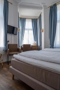 Schlafzimmer mit einem großen Bett und blauen Vorhängen in der Unterkunft Alt-Emder Bürgerhaus in Emden