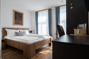 ein Schlafzimmer mit einem Bett, einem Schreibtisch und einem Fenster in der Unterkunft Alt-Emder Bürgerhaus in Emden