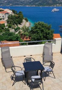 a table and chairs on a patio with a view of the ocean at Korkyra Melaina in Korčula