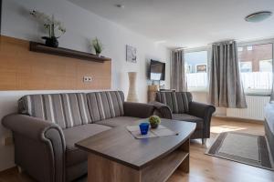 ein Wohnzimmer mit einer Couch und einem Tisch in der Unterkunft Alt-Emder Bürgerhaus in Emden