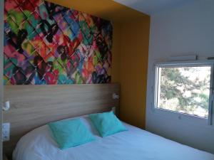 Bett in einem Zimmer mit Wandgemälde in der Unterkunft Kyriad Direct Orleans - Olivet - La Source in Olivet