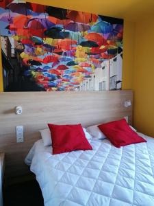 a bedroom with a bed with a painting of umbrellas at Kyriad Direct Orleans - Olivet - La Source in Olivet